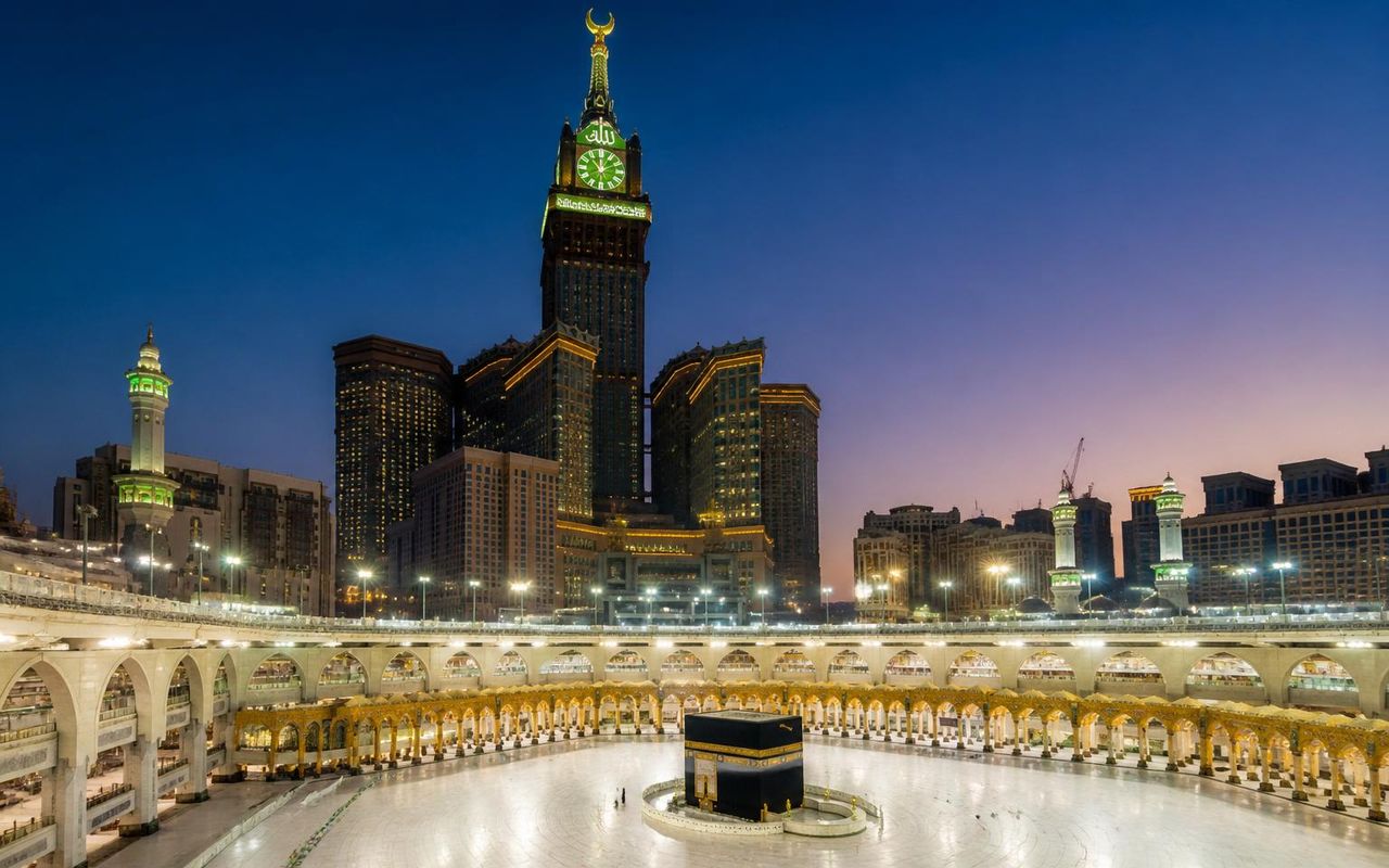 Package Makkah Hotels — Masjid Al Haram and the Makkah Clock Tower illuminated at dusk